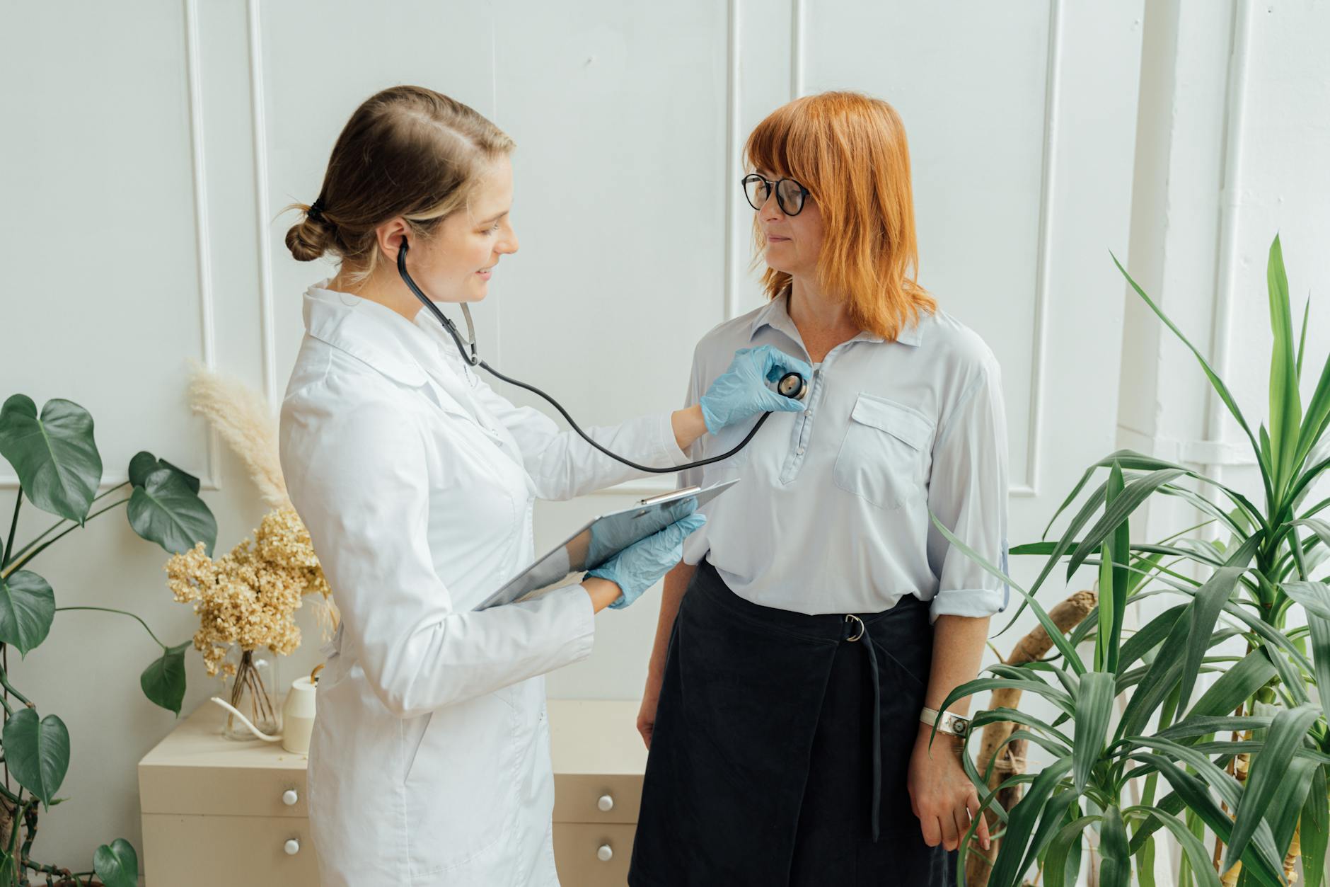 Ärztin hört Patientin mit Stethoskop ab