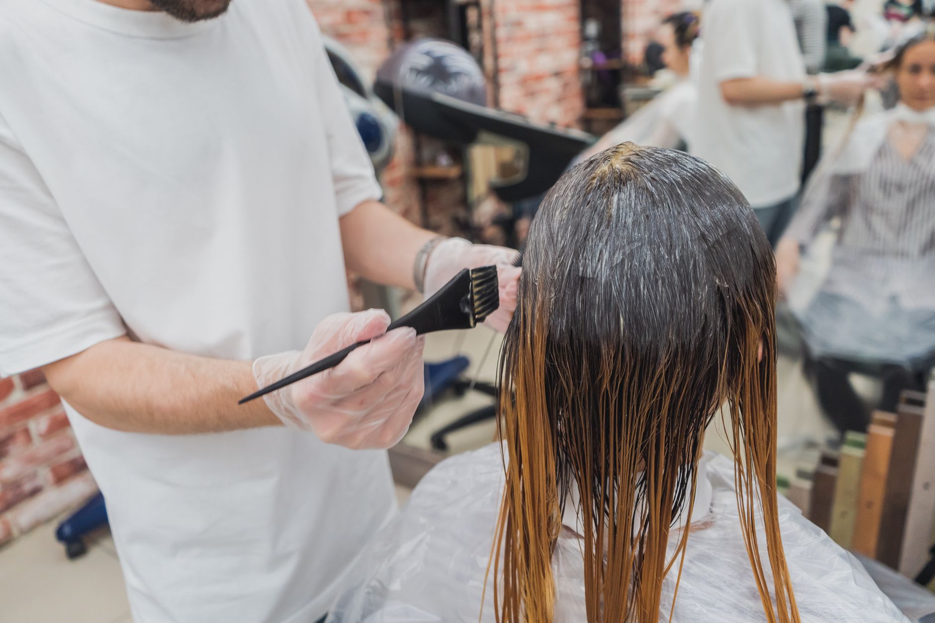 Coloristin trägt Farbe mit dem Pinsel auf