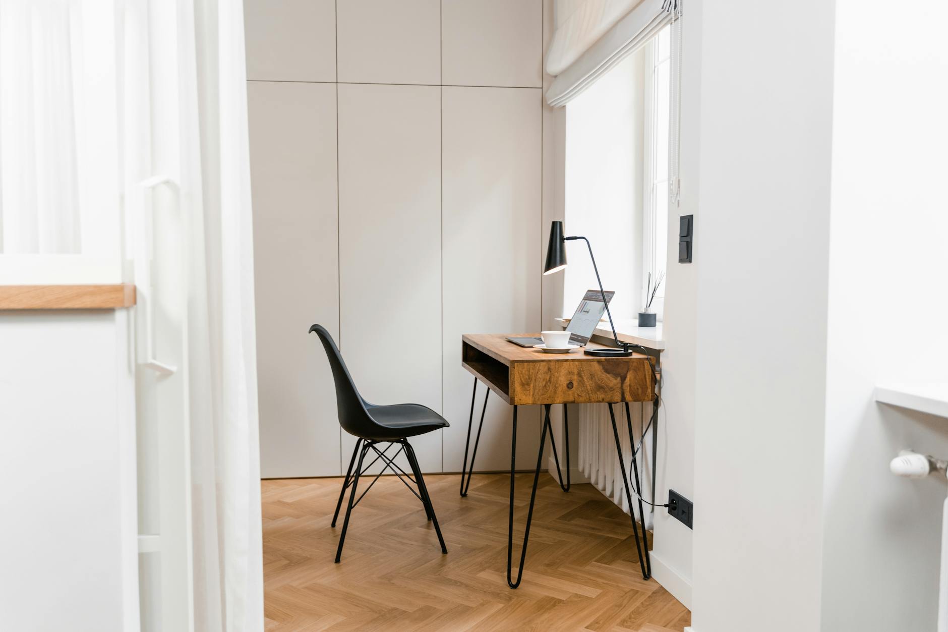 Heller, minimalistischer Konsultationsraum mit Walnussschreibtisch und Eames-Stuhl.