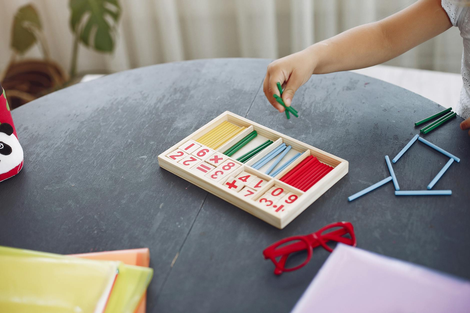 Kind arbeitet konzentriert mit Holz-Lernmaterial